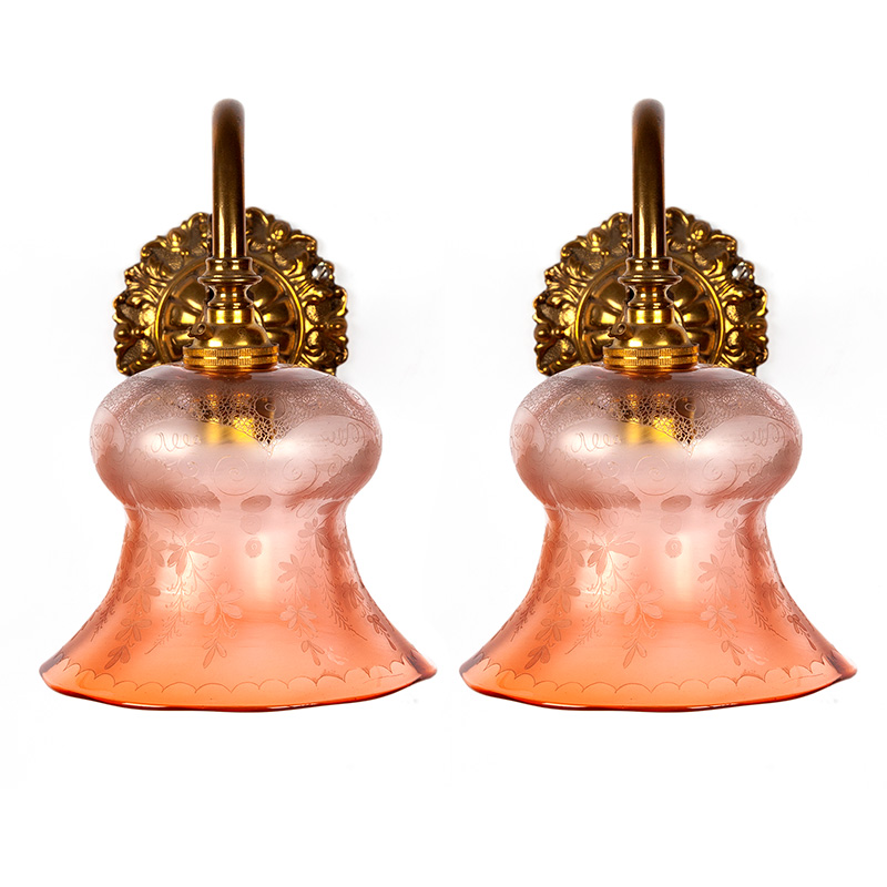 Pair of leafy Edwardian cast brass wall lights supporting fluted gradating orange glass shades decorated with floral motifs. (c.1905).