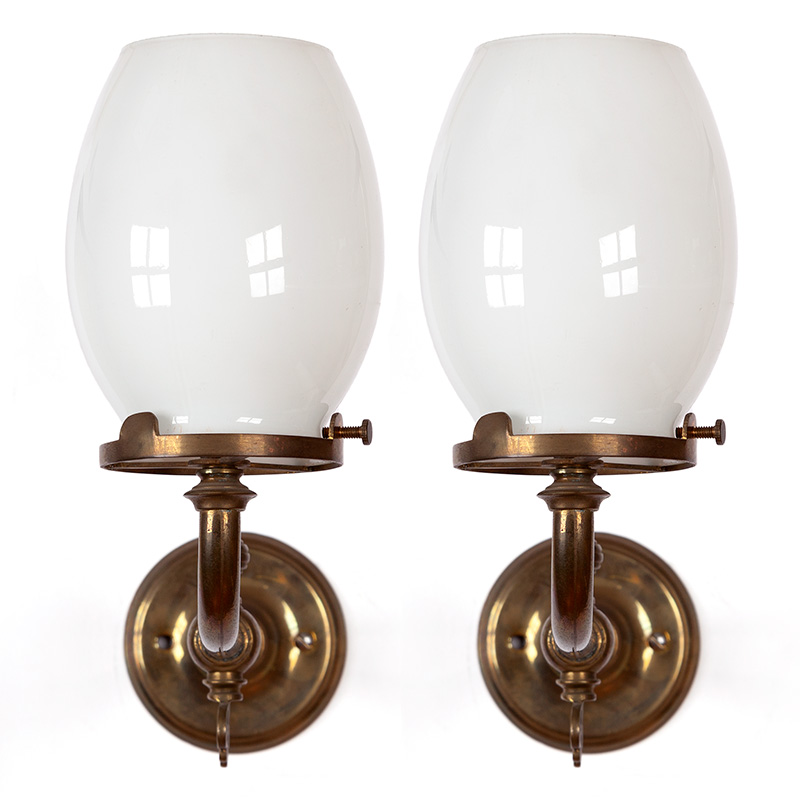 Pair of gas converted patinated cast brass Victorian wall lights fitted with oval-shaped opal glass shades. (c.1905)